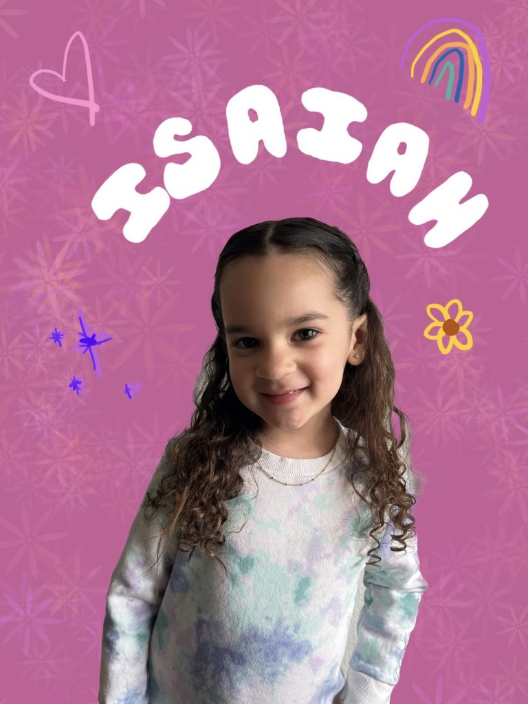 girl smiling in front of a pink background with floral print